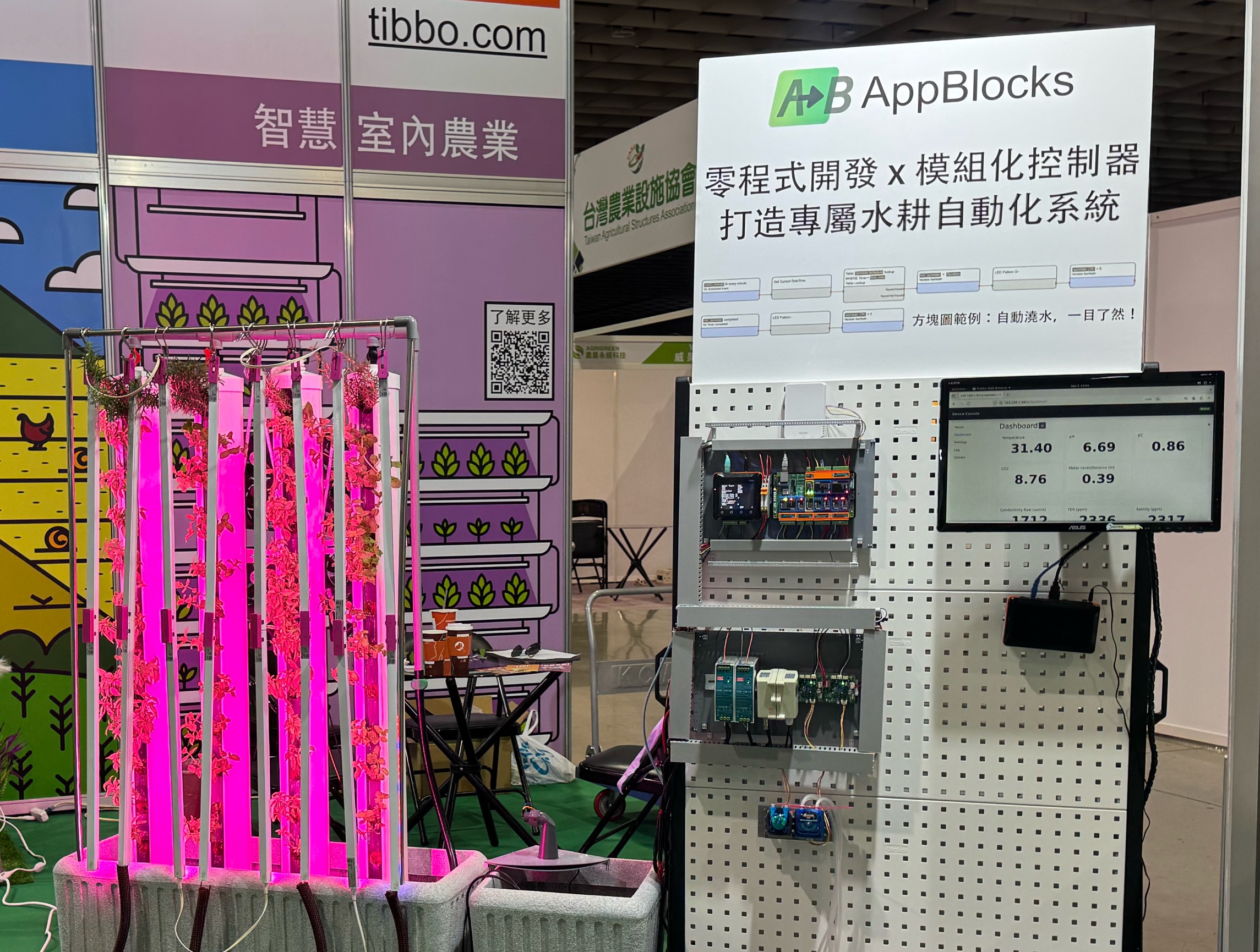 Test rack displaying an electrical panel with a controller for an indoors, vertical hydroponic farm at an expo booth.